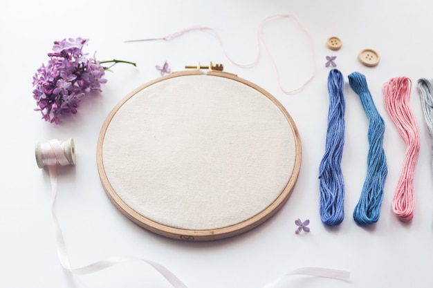 Flat lay top view photo of a mockup with embroidery hoop and flilac flowers. Stylish feminine floral mock-up.