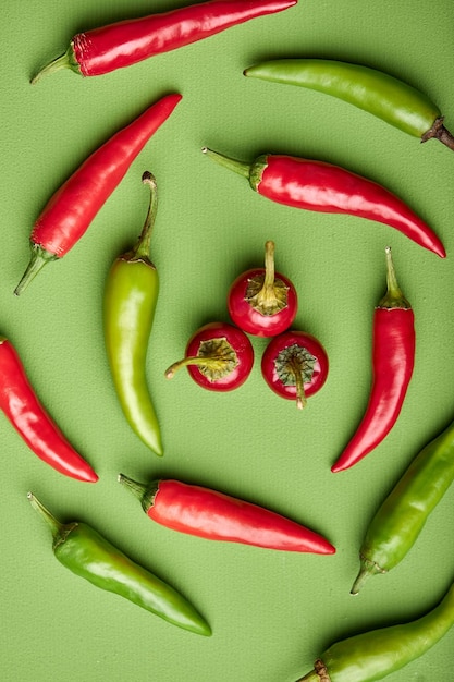 Flat lay top view of Red and green chili peppers isolated on green background lying on circle copy space above view vegetables concept