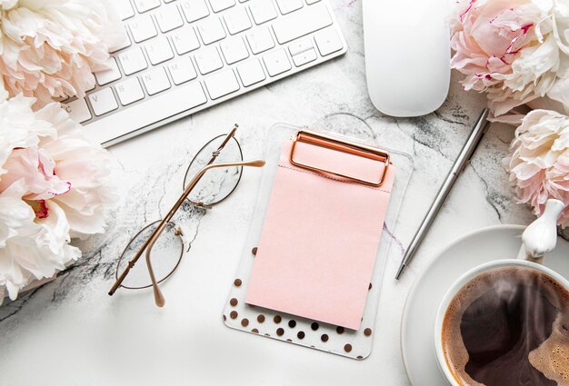 Foto flat lay top view vrouwelijk kantoor bureau met bloemen