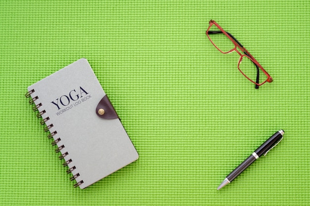 Flat lay top view of yoga workout log book on yoga mat back