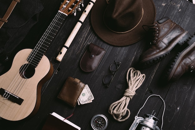 Flat lay of travel things on vintage wooden desk.