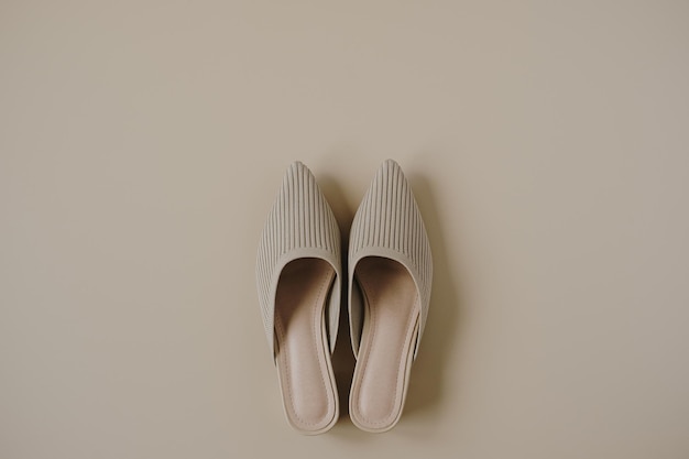 Flat lay of trendy female shoes on neutral pastel beige background Aesthetic luxury fashion accessory Top view