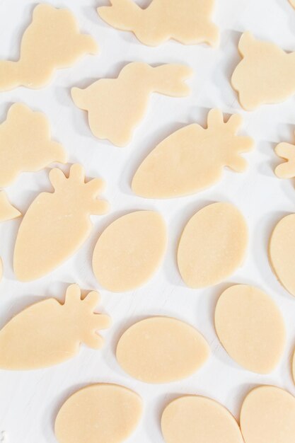 Flat lay. Unbaked Easter sugar cookies on a white table.