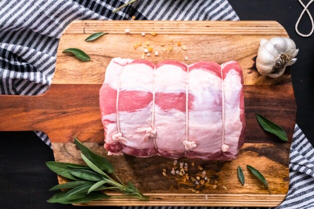 Photo flat lay. uncooked boneless pork roast on the cutting board.