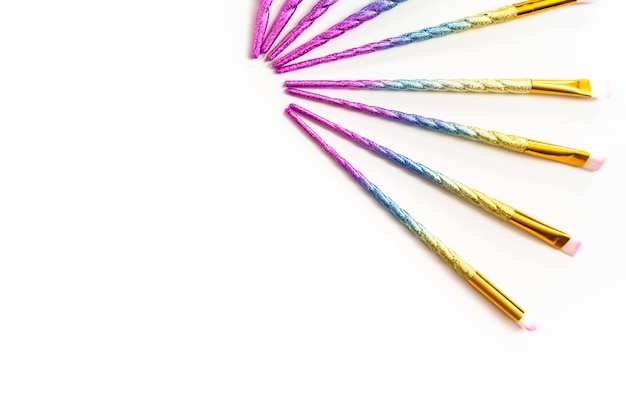 Foto disposizione piatta. set di pennelli per il trucco a tema unicorno su sfondo bianco.