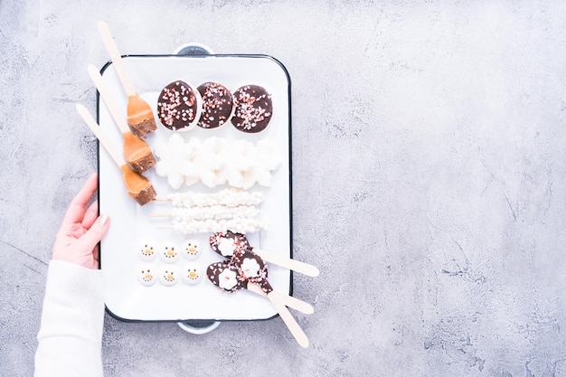 Flat lay. Variety of marshmallow toppings for hot chocolate and cocoa drinks on a white tray.