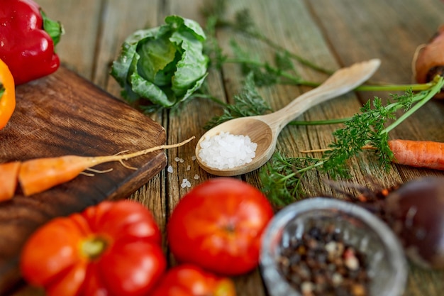 Flat lay of various organic vegetables ingredients and spicy on wooden surface