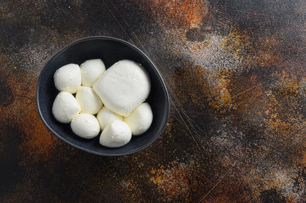 Flat lay of various sizes of Mozzarella cheese balls in bowl