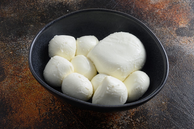 Flat lay of various sizes of Mozzarella cheese balls in bowl