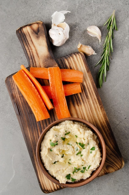 Flat lay view at vegetable Hummus dip dish topped with chickpeas and olive oil served with carrot slices