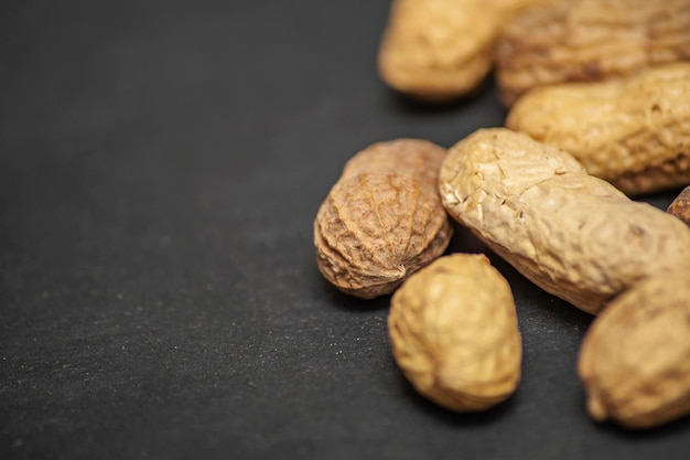 Flat lay wave shape of roasted unsalted peanuts peanuts in skin and peanuts in shell food ingredients Arachis hypogaea