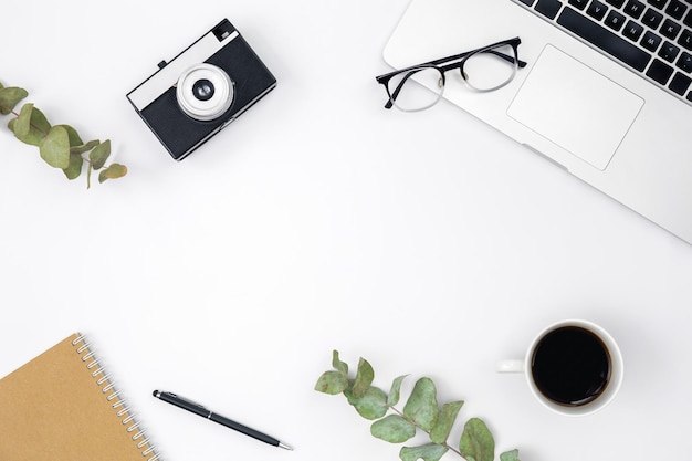 Photo flat lay white background with laptop retro camera coffee cup and glasses