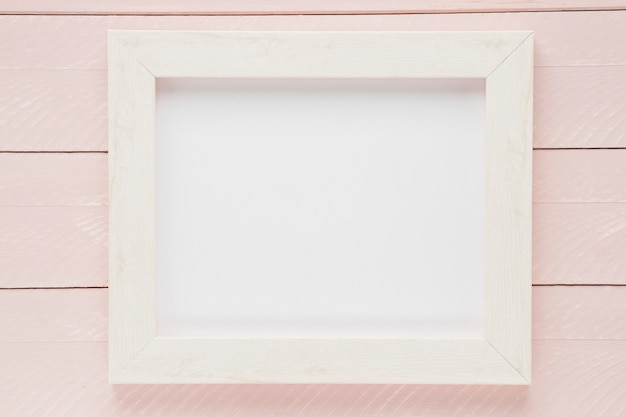 Photo flat lay white empty frame with wooden background