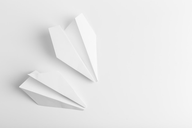 Flat lay of white paper plane on white color background