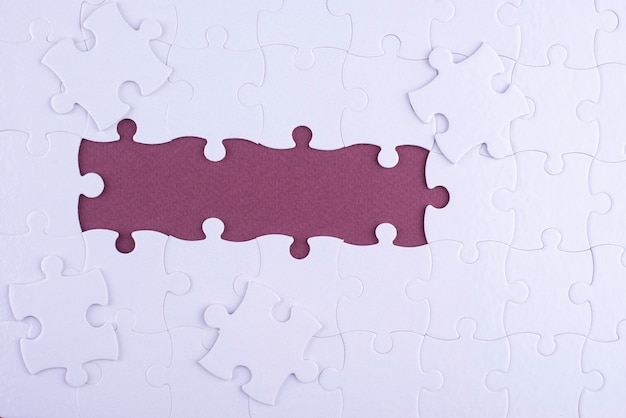 Flat lay white puzzle pieces and purple background