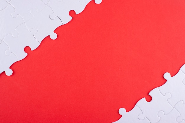 Flat lay white puzzle pieces and red background