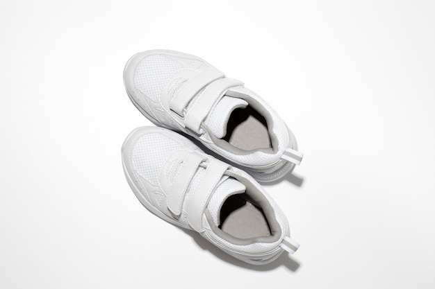 Flat lay white sneakers with velcro fasteners for pregnant women or people with disabilities isolate...