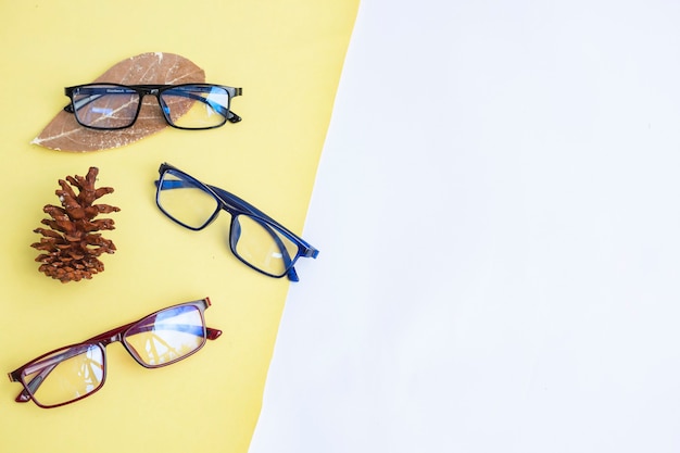 Flat lay with blank copy space. three glasses and leaves on a white and yellow background. minimalist concept idea