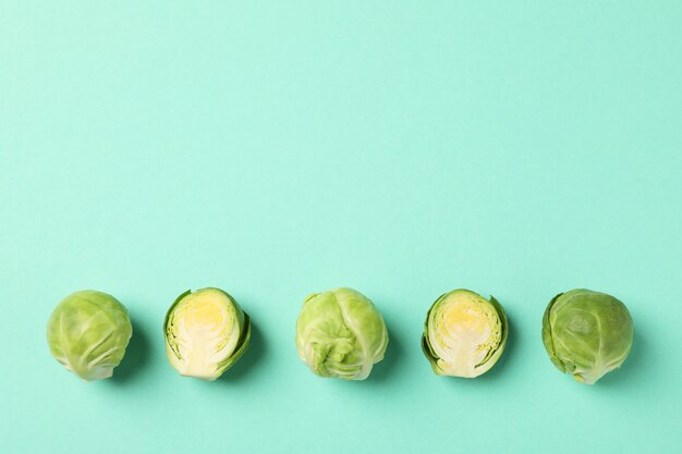 Flat lay with brussels sprout on green background, top view