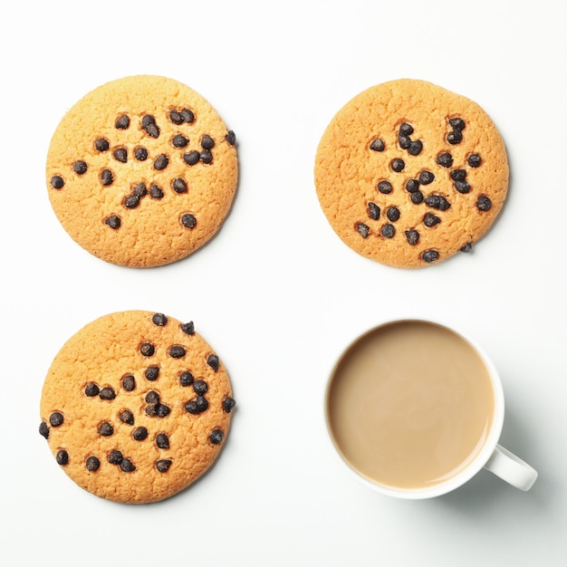 Flat lay with chocolate chip cookies and hot drink on white background