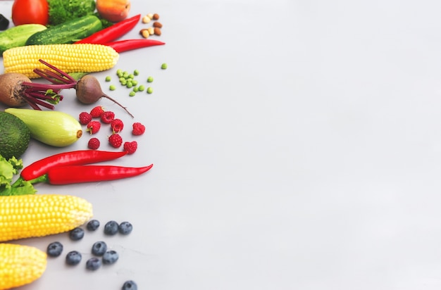 Flat lay with different vegetables, fruits, berries, nuts, spices, herbs, olive oil. Copy space area for some text. Veggies on grey concrete background. Concept of organic bio food healthy eating