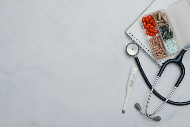 Photo flat lay with doctor desk table with stethoscope, medicine, notebook, office supplies