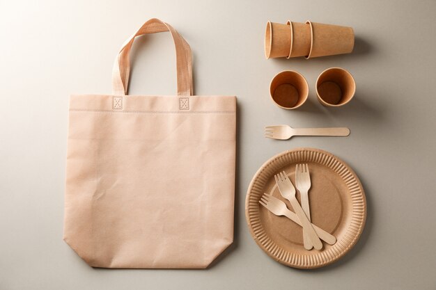 Photo flat lay with eco - friendly tableware on grey, space for text