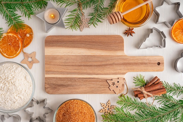 Flat lay with empty chopping board and ingredients for cooking as flour, honey, sugar and cinnamon