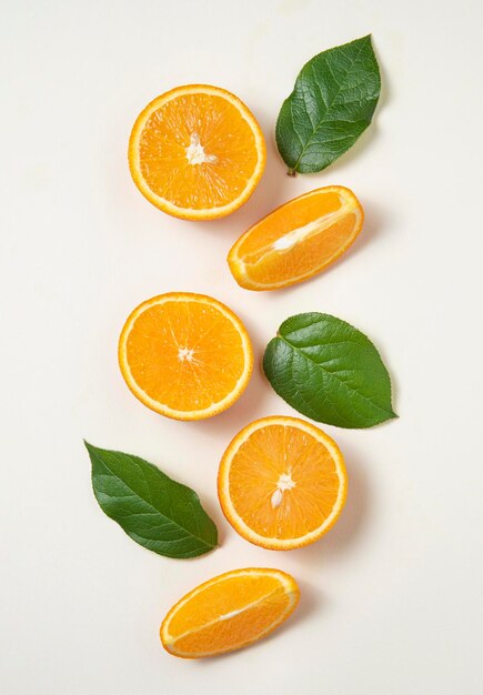 Flat lay with fresh juicy orange slices with green leaves on a yellow background. Top view