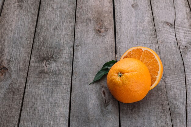 회색 나무 표면에 오렌지 과일의 신선한 익은 슬라이스 반으로 평평한 누워