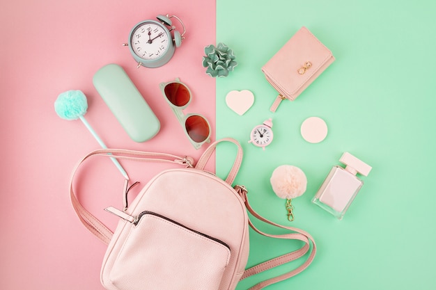 Flat lay with girls hand bag and accessories in pink and mint colors