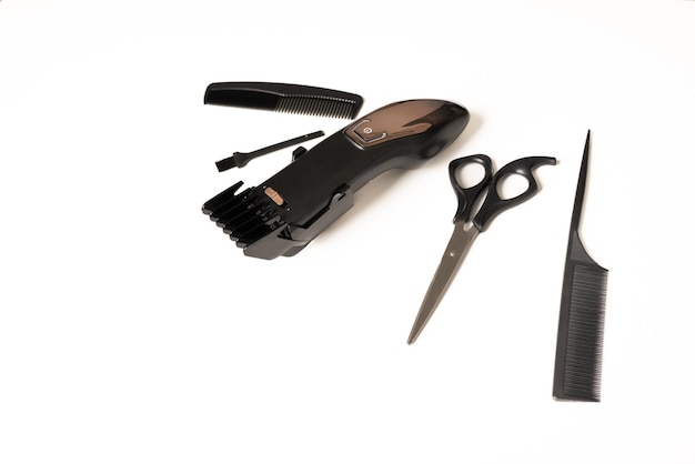 Flat lay with hair clipper and hairdressing tools, on white