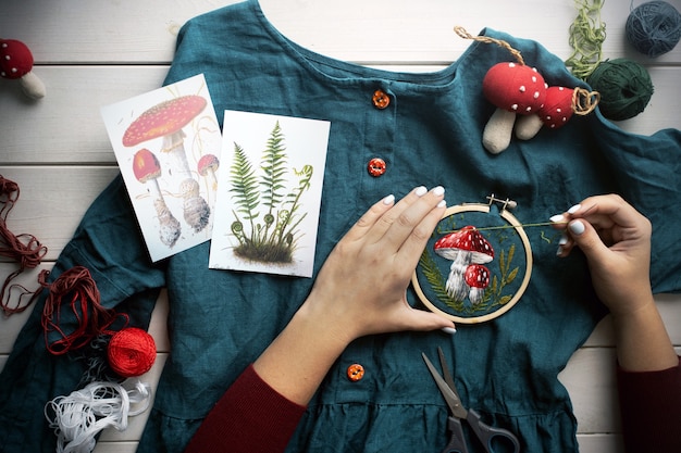 Flat lay with handmade fly agaric mushroom embroidery on dress