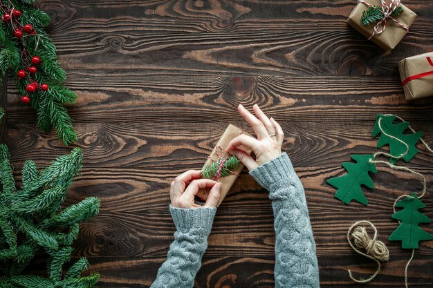 Flat lay with hands tying a bow on a gift box