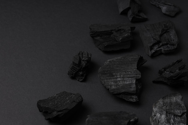 Фото Плоская лежала с натуральным углем на черном фоне