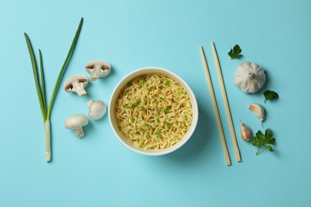 Flat lay with noodles and ingredients on blue