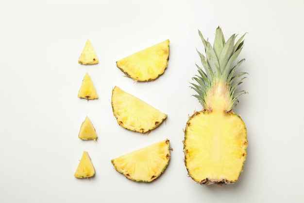 Flat lay with pineapple and slices on white background