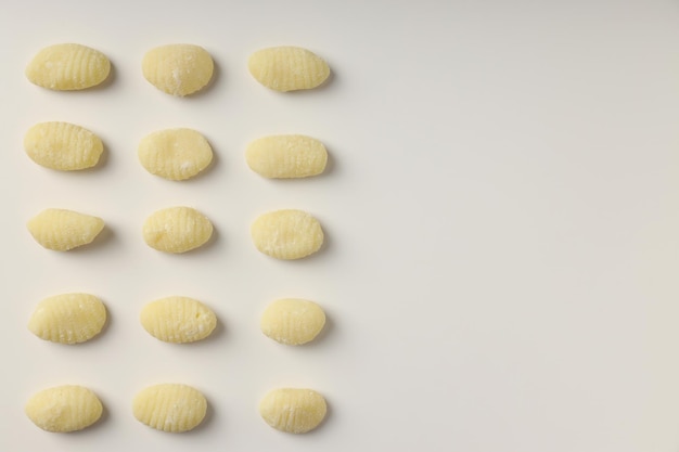 Flat lay with raw potato gnocchi on white background