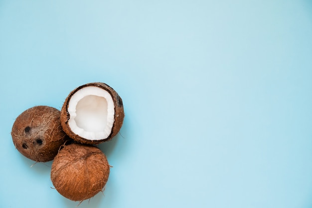 Flat lay with ripe coconuts on blue 