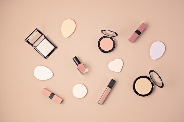 Flat lay with set of professional decorative cosmetics, makeup tools and woman spring, summer accessories over pink wall with copy space. Beauty blog, fashion, party, shopping concept. Top view