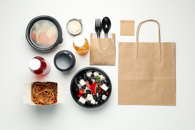 Flat lay with takeaway food on white wall. Food delivery