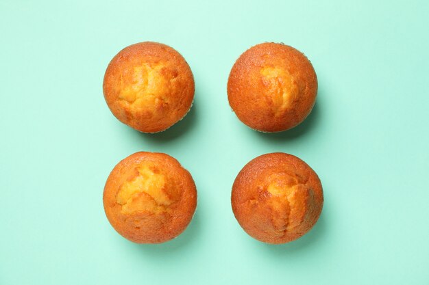 Flat lay with tasty muffins on mint background, top view