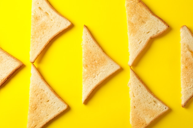 Flat lay with toast breads on yellow background