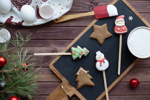 Flat lay with traditional Christmas Gingerbread. Process of homemade decoration. New year colors. Winter holidays mood and family leisure activity concept