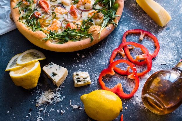 Flat lay with traditional Italian pizza with shrimp, mozzarella and arugula 