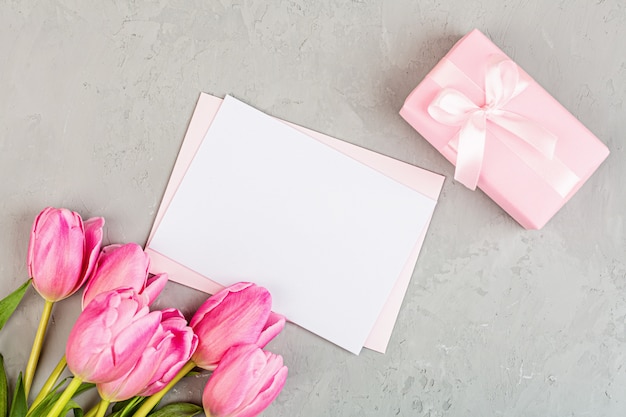 Piatto disteso con tulipani e confezione regalo con copia spazio su grigio