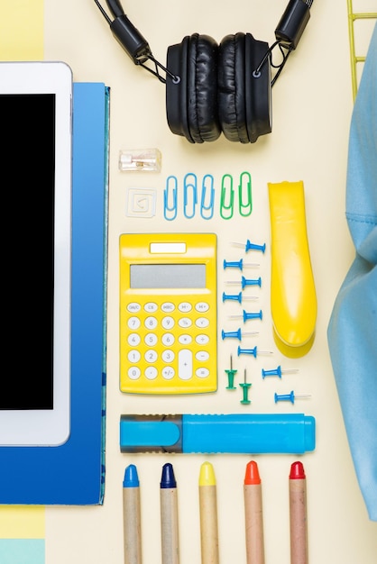 Flat lay with various school supplies on colorful surface