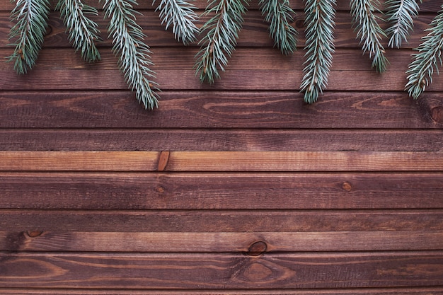 Flat lay with wooden table and silver spruce. Christmas and new year background in brown and green.