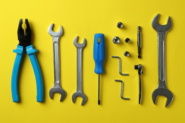 Flat lay with working tools on yellow background