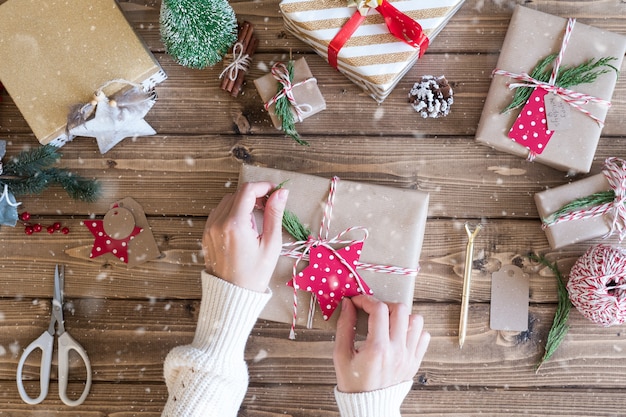 Flat lay of Woman s hands wrapping Christmas gift